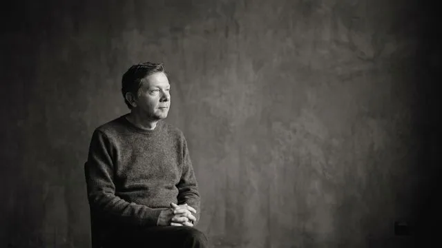Eckhart Tolle in a beige cardigan with overlay text reading "There are TWO of YOU" in bold colored letters