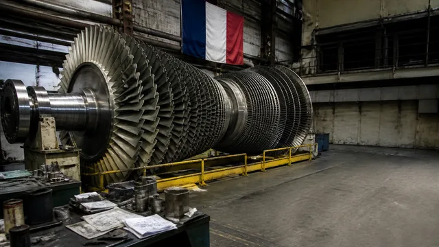 Close-up of large industrial nuclear turbine rotors with concentric metal blades stacked inside machinery housing