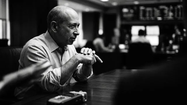 Senior executive in office setting with Wall Street Crash newspapers and financial memorabilia in background